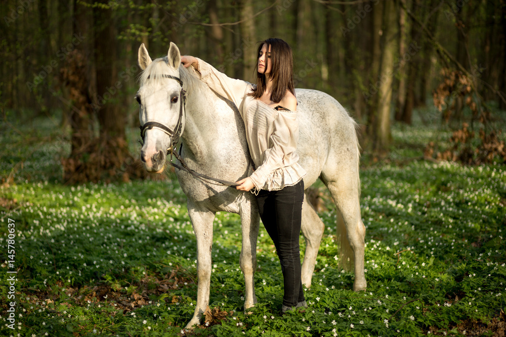Young beautiful woman with a horse. Female rider and horse in the spring forest. Woman in boho style. Young beautiful woman with a horse. Female rider and horse in the spring forest. Woman in boho style.