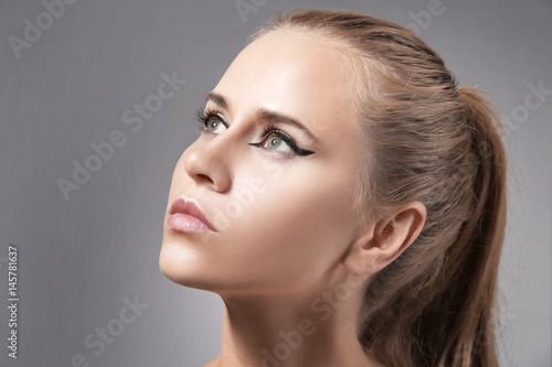 Beautiful young girl face on color background