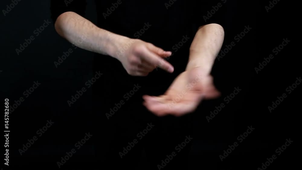 magician shows coin trick on black background magician shows coin trick on black background