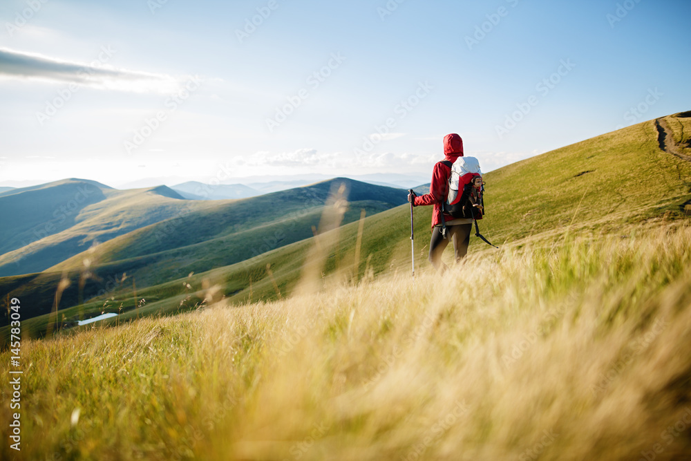 Tourist with backpack. Hike in the mountains. Woman traveler with backpack on beautiful summer landscape. Travel concept with space for text