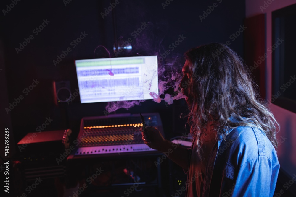 Male audio engineer smoking electronic cigarette Male audio engineer smoking electronic cigarette