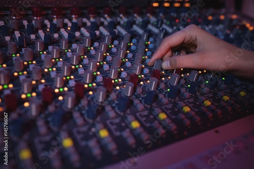 Hands of female audio engineer using sound mixer