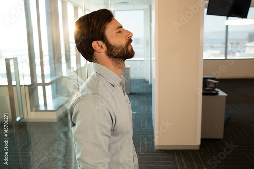 Side view of sad businessman leaning on glass