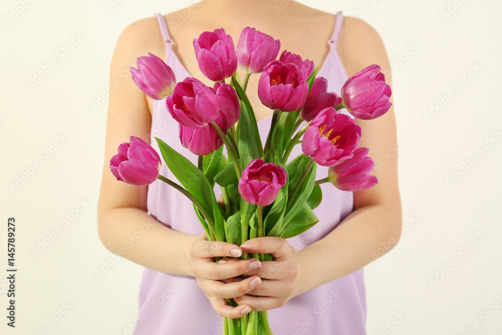 Young woman with bouquet of beautiful lilac tulips on white background, closeup Young woman with bouquet of beautiful lilac tulips on white background, closeup