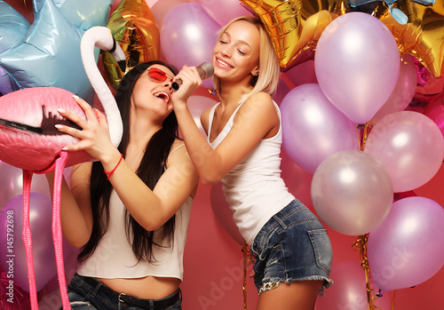 lifestyle, party and people concept: Happy girls with microphon