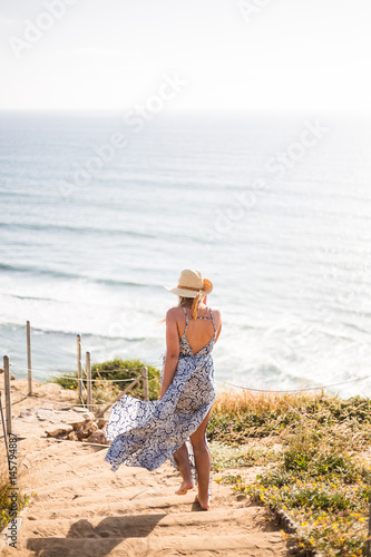 Young woman, female, blonde girl staying on the cliff in a long, chiffon, flying dress. San Diego. California. Summer. Enjoy life