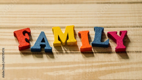 The word family out of colored wooden letters on the table.
