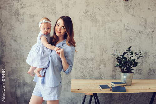 happy mother and baby playing at home in bedroom. Cozy family lifestyle in modern scandinavian interior.
