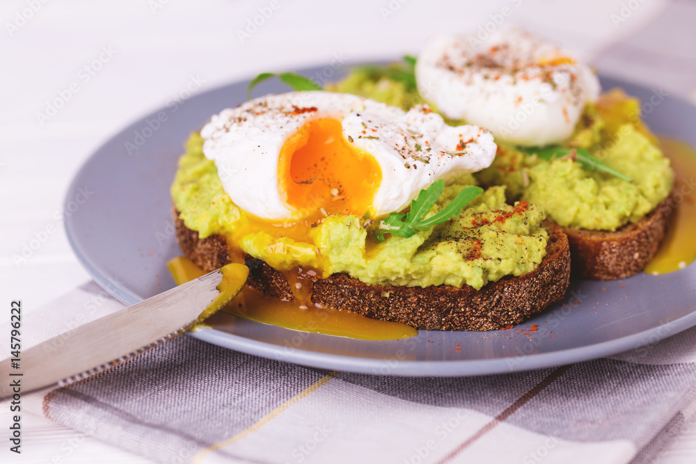 Toast with poached egg, puree avocado, spices and arugula Toast with poached egg, puree avocado, spices and arugula