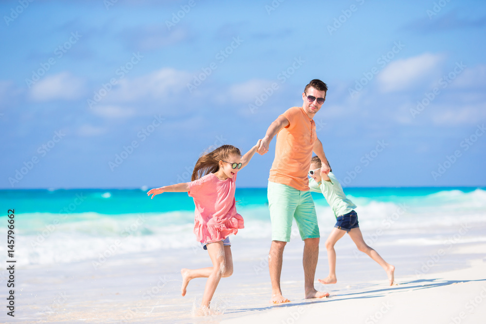 Happy family at tropical beach having fun