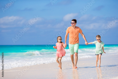 Family walking on white tropical beach on caribbean island © travnikovstudio