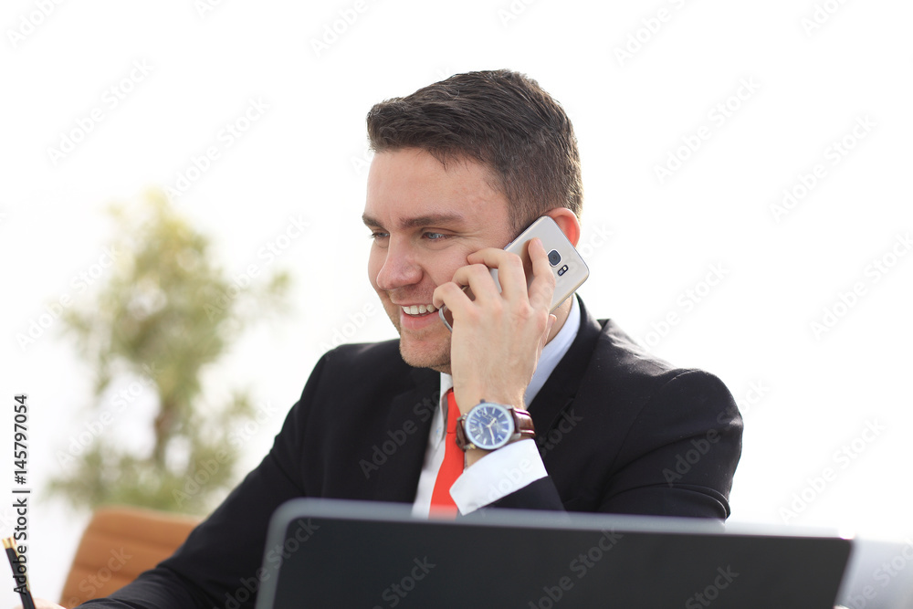 Good business talk. Handsome young man in formalwear talking on the phone and smiling while sitting Good business talk. Handsome young man in formalwear talking on the phone and smiling while sitting