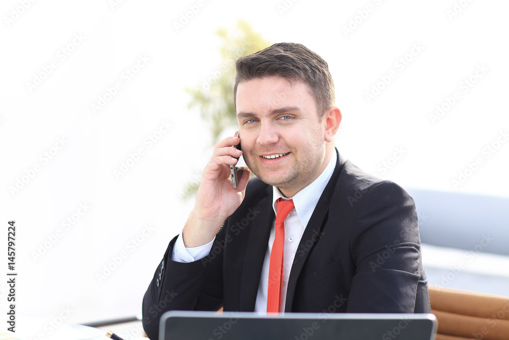 Good business talk. Handsome young man in formalwear talking on the phone and smiling while sitting Good business talk. Handsome young man in formalwear talking on the phone and smiling while sitting