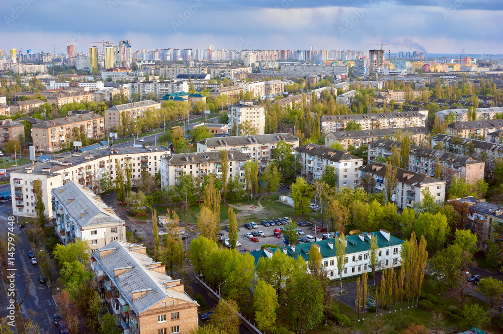 The aerial View of urban residential district in Kyiv,Ukraine in spring.View over the city rooftops with sunlight at Darnitsa suburb.Moderns buildings at Industrial uptown;residential neighbourhood.