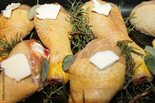 chicken legs brews in a baking pan with sage and rosemary photo