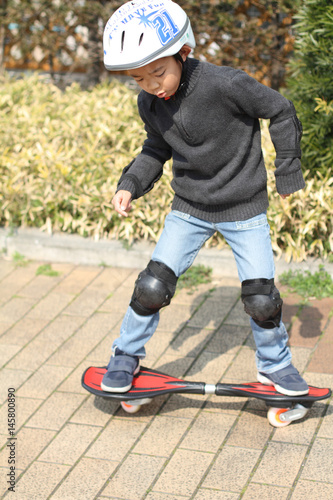 Japanese boy riding on a casterboard (first grade at elementary school)