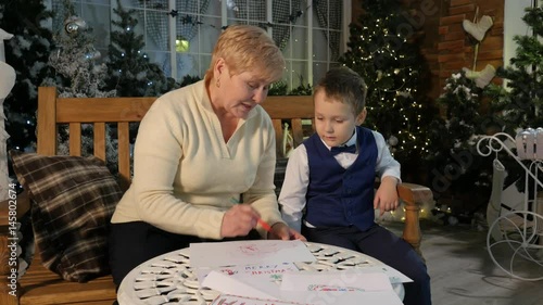 Aunt Teaches Little Nephew to Draw Christmas Eve at Home Grandmother Came to Visit Grandson Cute Well-Dressed Little Boy With a Bow-Tie and Middle Age Woman