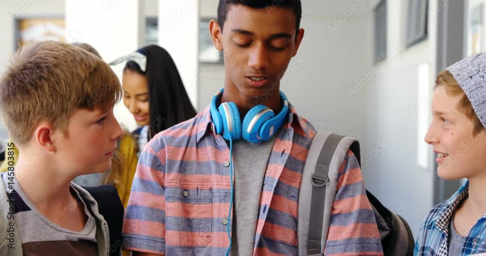 Students standing with notebook and digital tablet in corridor Students standing with notebook and digital tablet in corridor