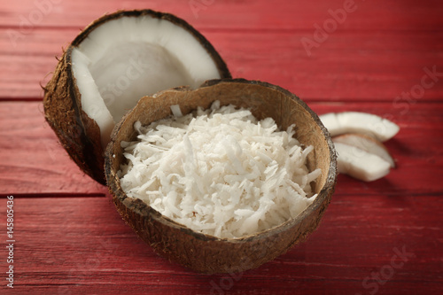 Grated coconut in shell on wooden background