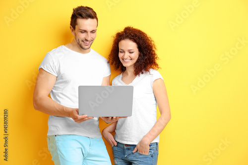 Happy young couple with lap...