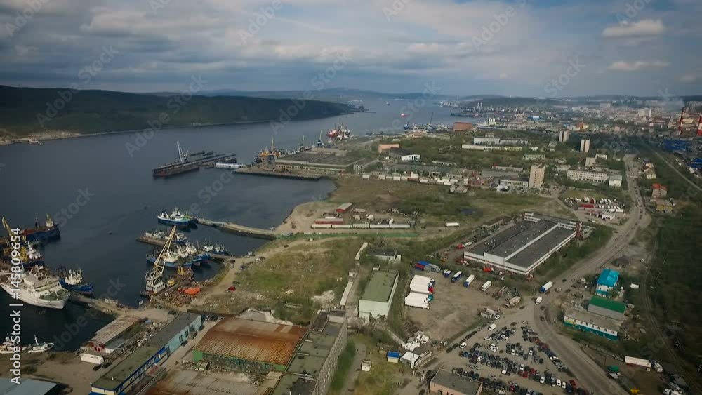 Murmansk Sea Port Panoramic View. Station Buildings, Roads on Shore. Boats in Bay. Ships Floating. Cloudy Summer Day. City on Background. Wide Shot Murmansk Sea Port Panoramic View. Station Buildings, Roads on Shore. Boats in Bay. Ships Floating. Cloudy Summer Day. City on Background. Wide Shot