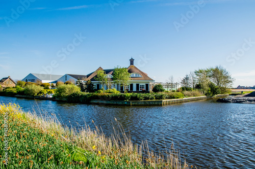 green landscape view with grass water and blue sky