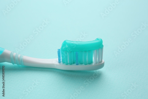 Toothbrush with paste on color background, closeup