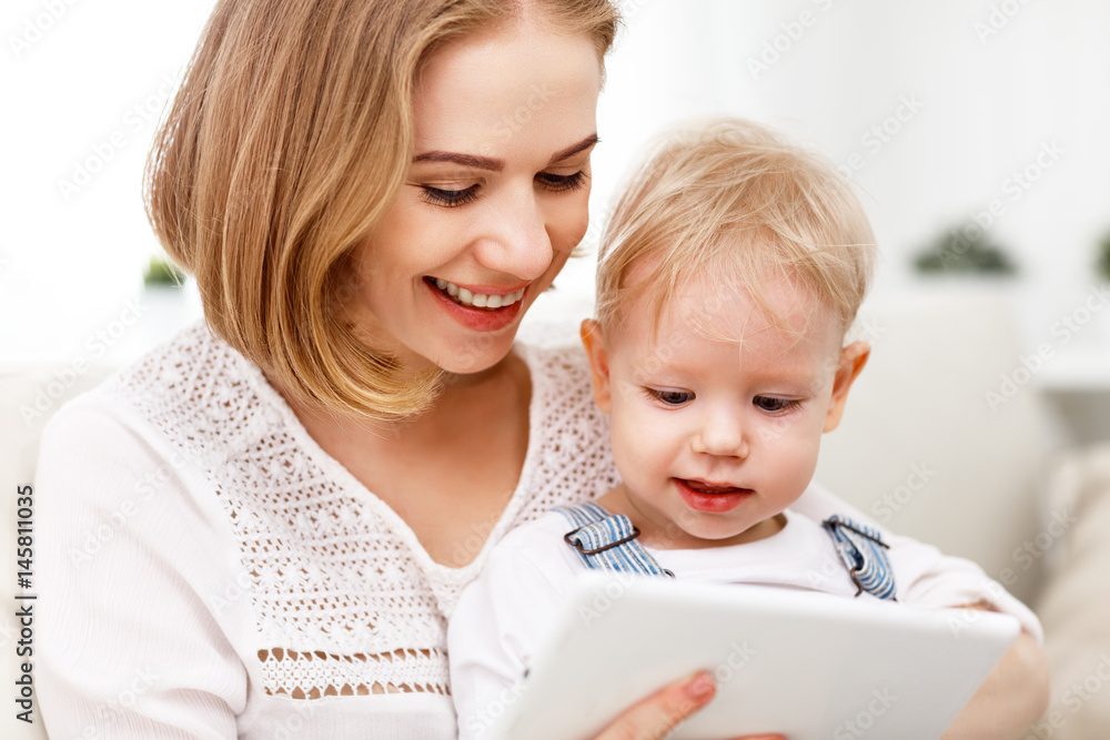 Mother and baby son with a tablet computer at home . Mother and baby son with a tablet computer at home .