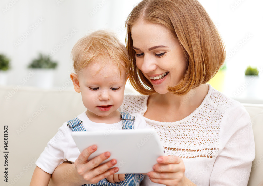 Mother and baby son with a tablet computer at home . Mother and baby son with a tablet computer at home .