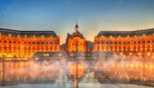 Iconic view of Place de la Bourse with tram and water mirror fountain in Bordeaux, France