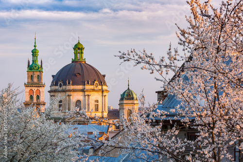 Lviv architecture. Dominican temple. Blossom trees in spring evening. photo