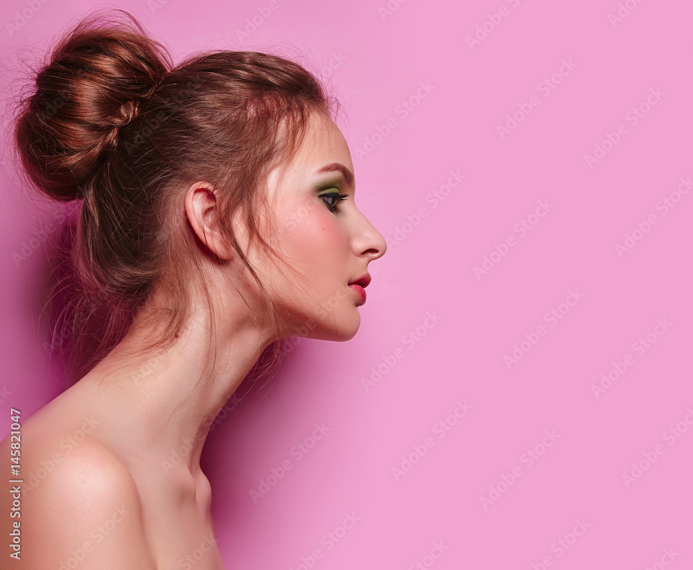 Beautiful young graceful girl with long neck on a pink background