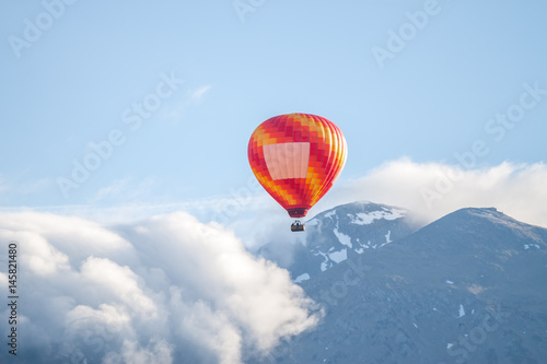 colorful air ballon over clouds and mountains