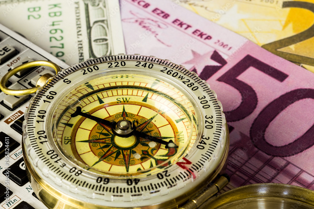 Tourist compass with banknotes on wooden table Tourist compass with banknotes on wooden table