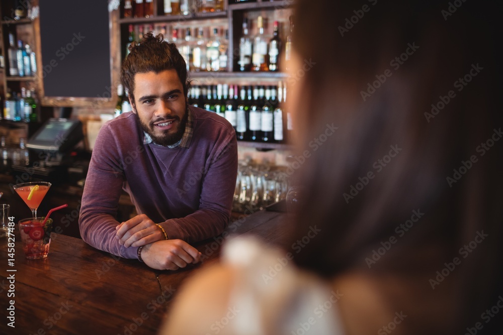Fototapeta premium Male bar tender interacting with customer at pub