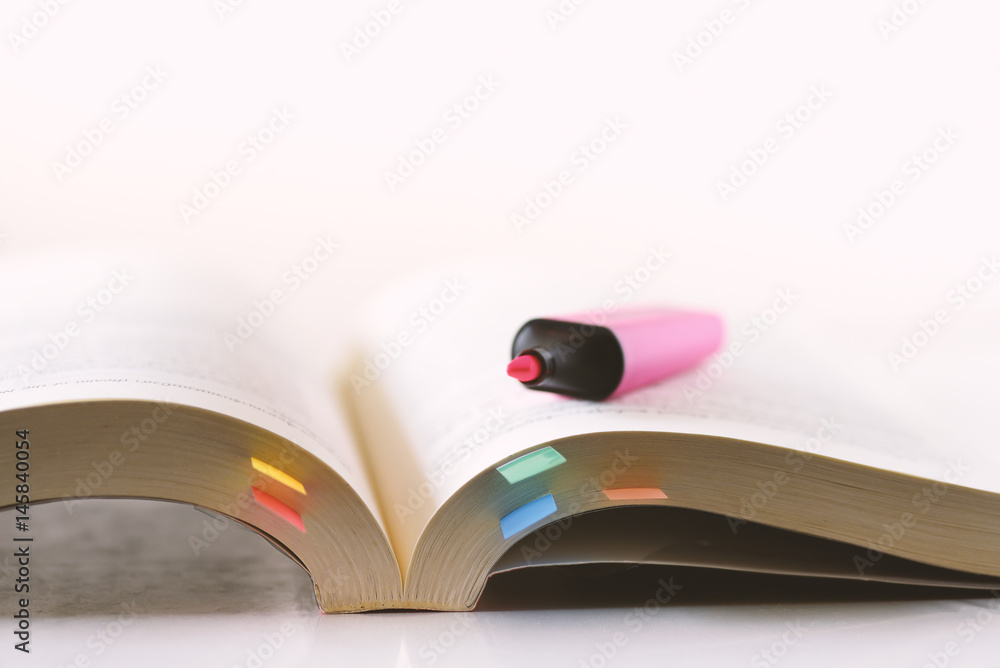 Fototapeta premium Education,Page of book with sticky note and highlighting pen on white background