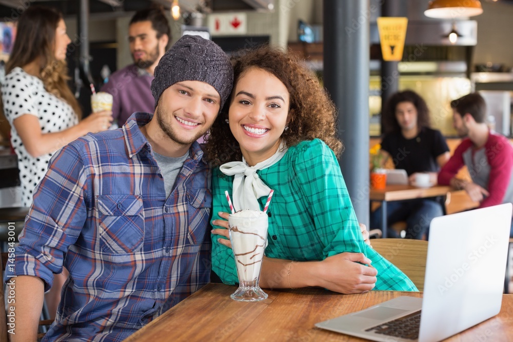 Obraz premium Portrait of smiling couple sitting in restaurant