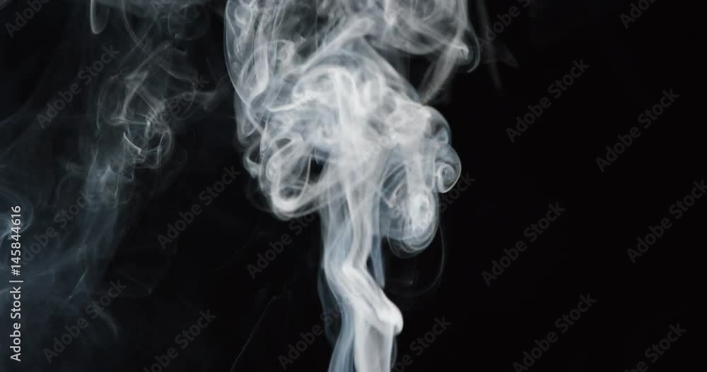 Clouds of white smoke rise into frame in slow motion on black background Clouds of white smoke rise into frame in slow motion on black background