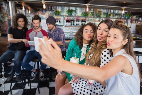 Photography Female friends taking selfie at restaurant