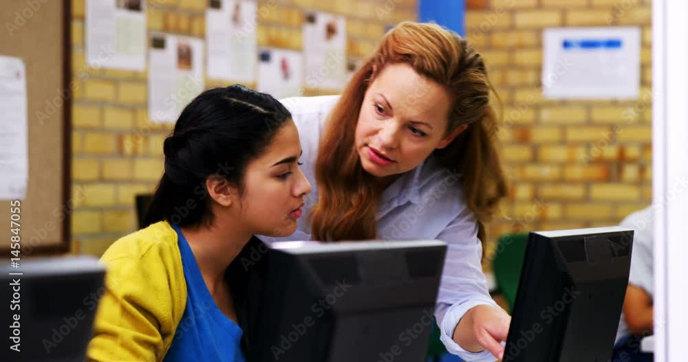 Teacher assisting schoolgirl in computer class Teacher assisting schoolgirl in computer class