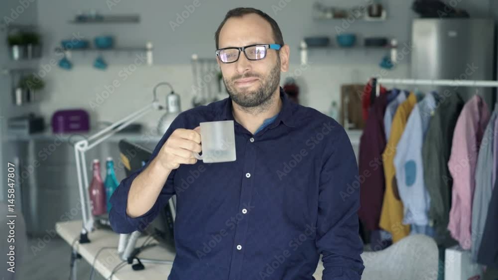 Young, happy man relaxing and drinking beverage at home
Young, happy man relaxing and drinking beverage at home