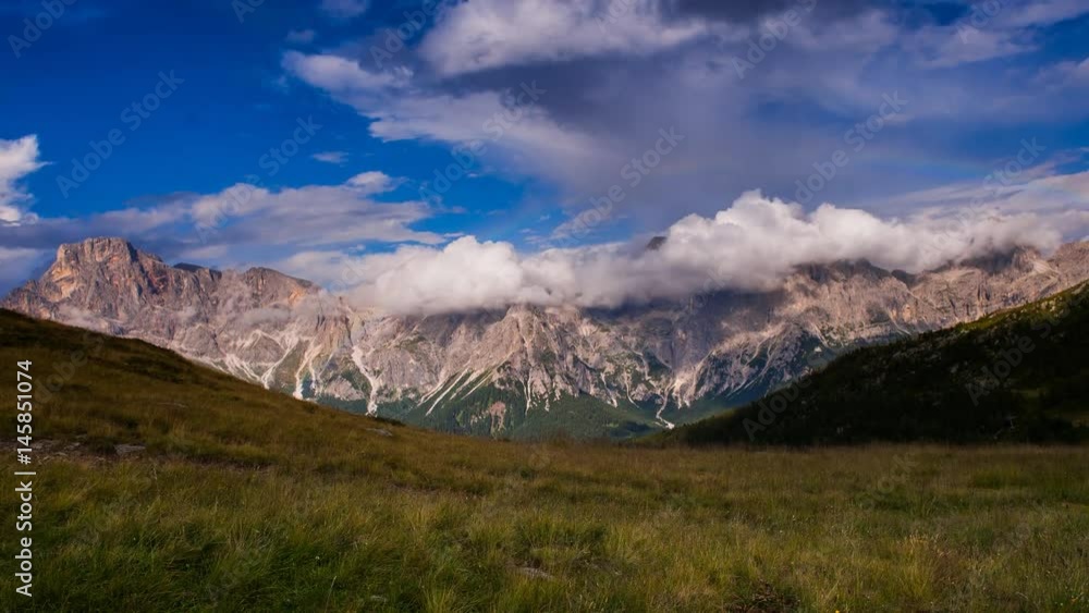 Time lapse of green valley with heavy clouds overhead and a rainbow. Time lapse of green valley with heavy clouds overhead and a rainbow.