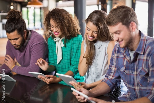 Friends using digital tablet in restaurant