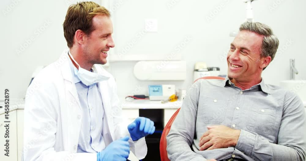 Smiling dentist and patient interacting with each other Smiling dentist and patient interacting with each other