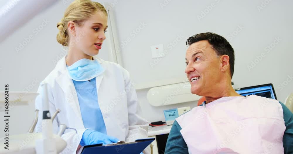 Dentist interacting with a male patient Dentist interacting with a male patient