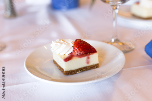 Cheesecake with cream and strawberry on the plate