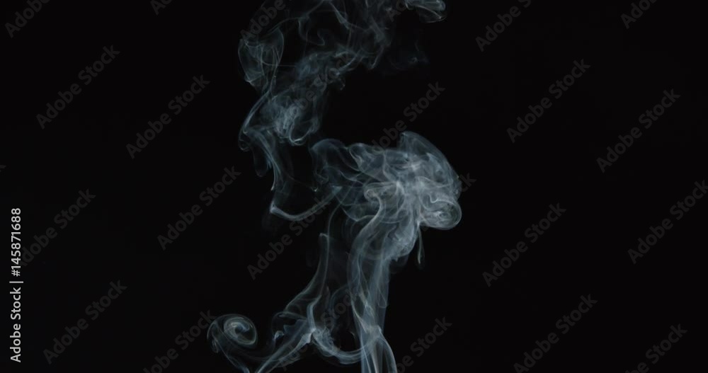 Wisps of turbulent smoke from a candle or cigarette rise into frame Wisps of turbulent smoke from a candle or cigarette rise into frame