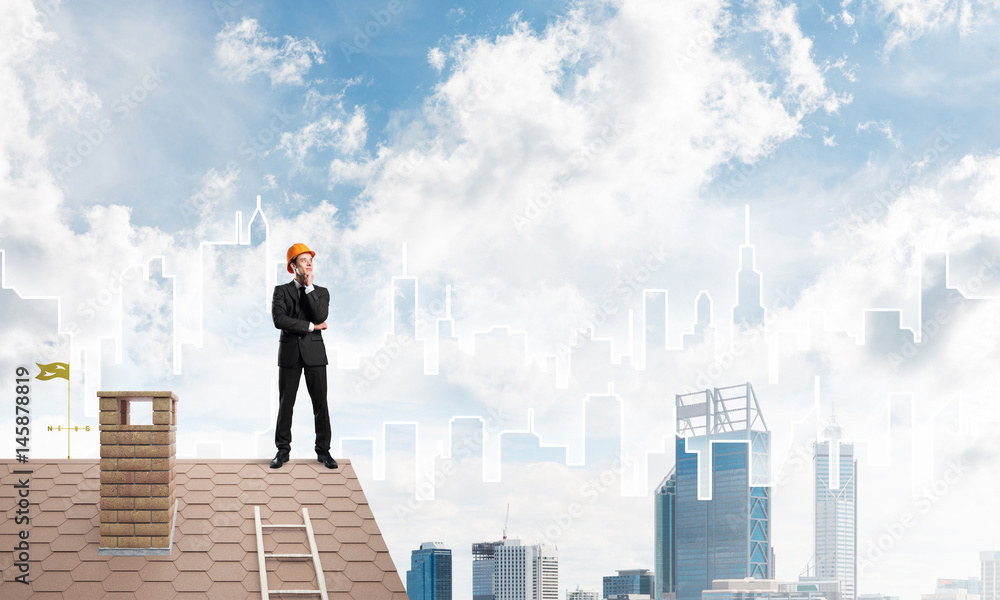 Engineer man standing on roof and looking away. Mixed media Engineer man standing on roof and looking away. Mixed media