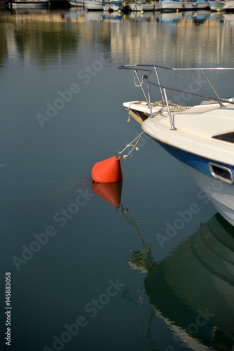 boat tied to buoy moored in harbor 