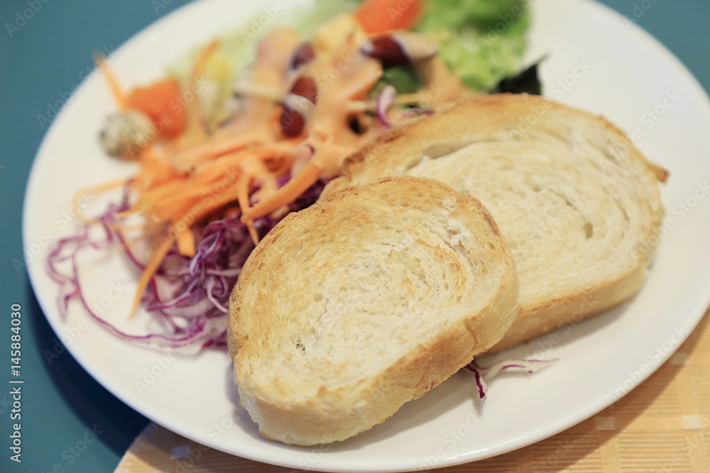 Baguette slice toast and fresh salad for breakfast.
